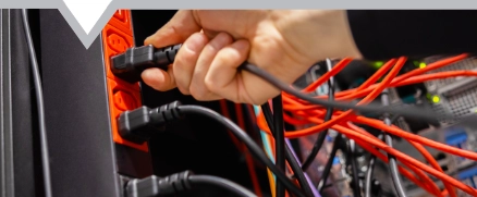 Close up of mans hand putting cable into a machine