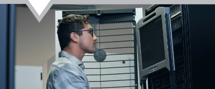 Close up shot of a techicain working on a computer accessing a server