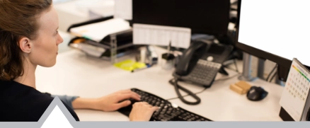 Woman tpying on a computer at her desk in a office