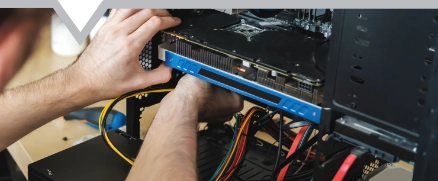 man repairs a computer system unit changes parts video card and hard drive sets components